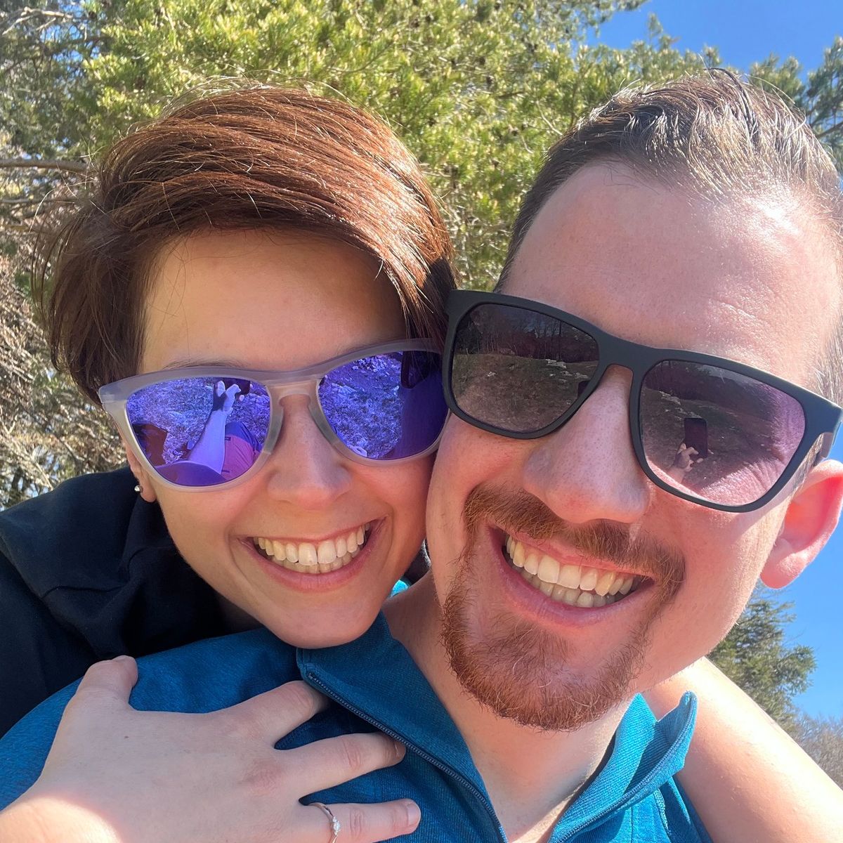 Joël und Larissa lachen umarmt im Freien